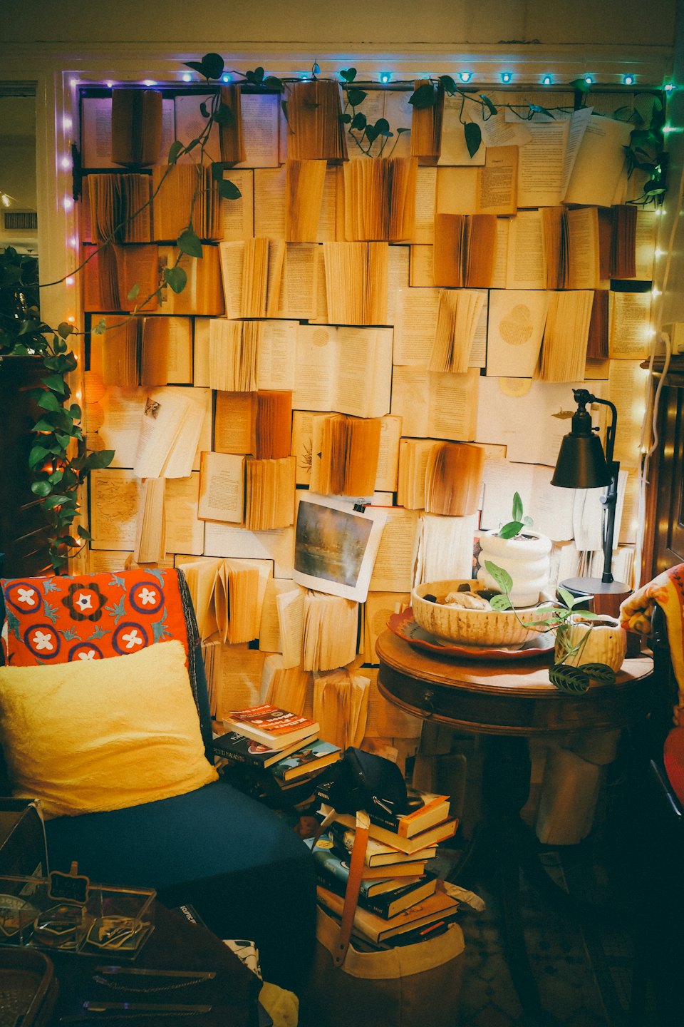 Armchair beside a wall decorated with open books and plants.